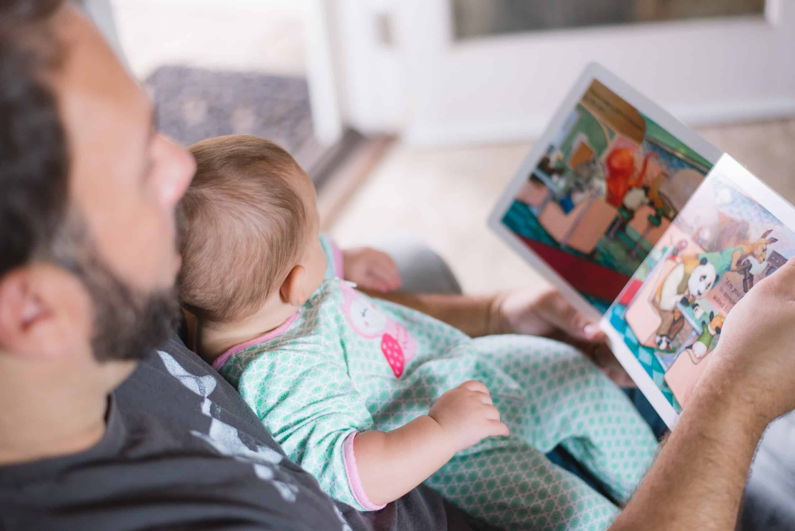 A man looks at a picture book with a toddler. Picture: Picsea on Unsplash 